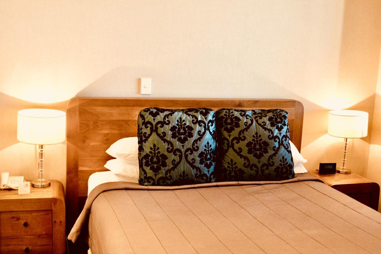ホテル ザ ノーチラス ネーピア エクステリア 写真 A bed with a decorative pillow